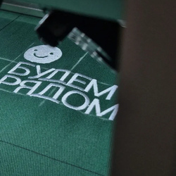 Процесс вышивки логотипа на футболке — вышивка принта на текстиль крупным планом